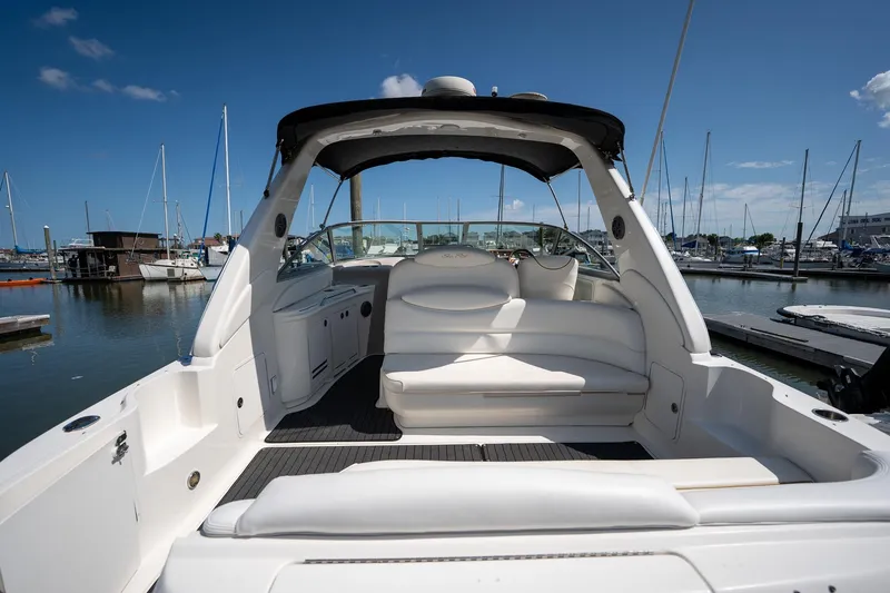 Slide: The Image of 2000 Sea Ray 340 Sundancer yacht interior at marina, showcasing sleek white seating and open deck. - 2