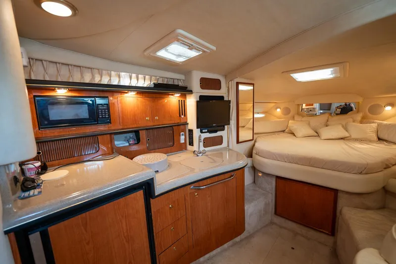 Slide: The Image of Interior of 2000 Sea Ray 340 Sundancer yacht with kitchenette and cozy sleeping area. - 20