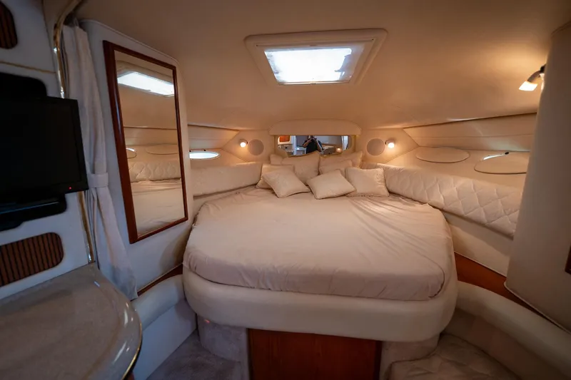 Slide: The Image of Interior cabin of 2000 Sea Ray 340 Sundancer yacht, featuring a cozy bed and elegant decor. - 27