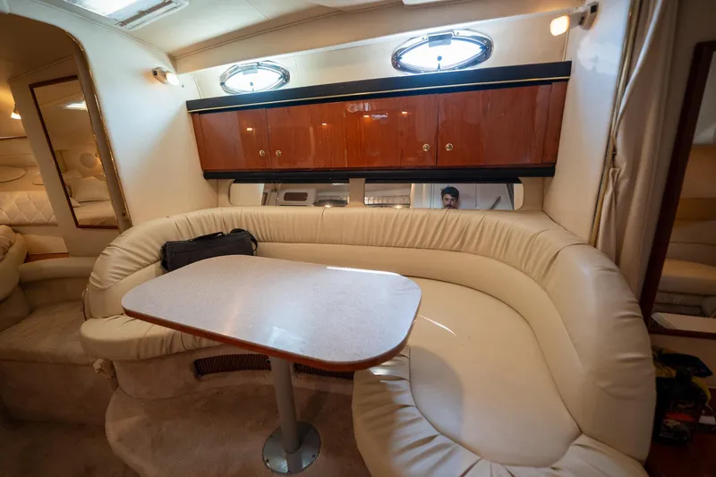 Slide: The Image of Interior of 2000 Sea Ray 340 Sundancer yacht with plush seating and wooden cabinets. - 29
