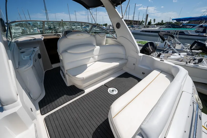 Slide: The Image of 2000 Sea Ray 340 Sundancer boat interior with white seating and marina view. - 7