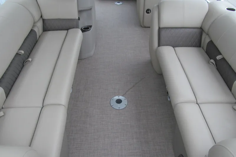 Slide: The Image of 2024 Sun Tracker Party Barge 20 DLX interior with beige seating and carpeted floor. - 7