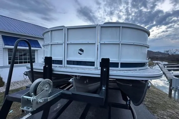 Slide: The Image of 2026 South Bay 222CR LE pontoon boat on trailer, under a cloudy sky. - 2