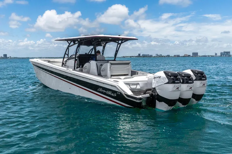 Slide: The Image of 2019 Nor-Tech 390 Sport Center Console boat on blue ocean with triple outboard engines. - 1