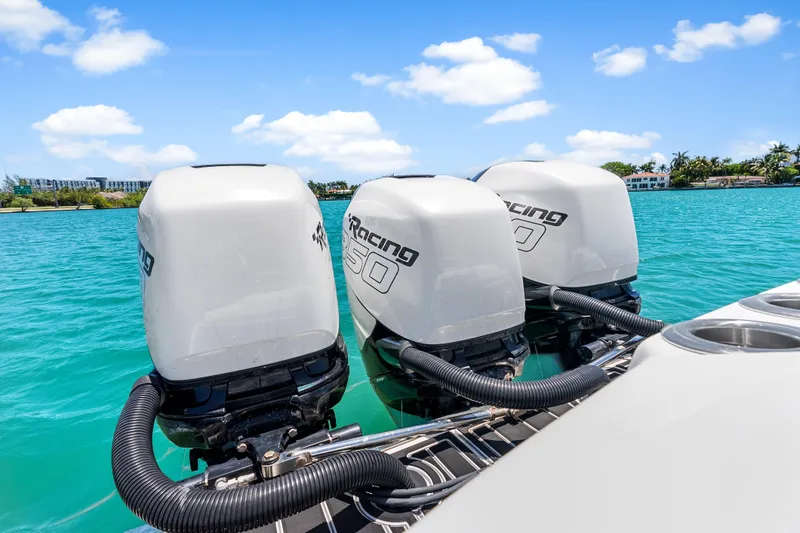 Slide: The Image of 2019 Nor-Tech 390 Sport Center Console with triple outboard engines on turquoise water. - 14