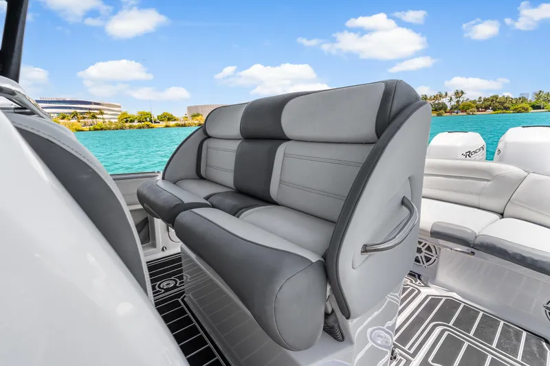 Slide: The Image of 2019 Nor-Tech 390 Sport Center Console boat interior with plush seating and scenic water view. - 16