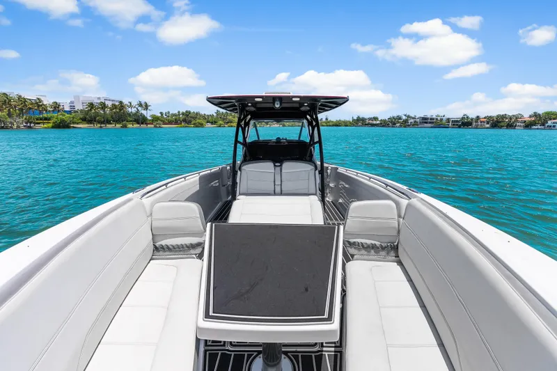 Slide: The Image of 2019 Nor-Tech 390 Sport Center Console on turquoise water, clear sky, luxury seating. - 27