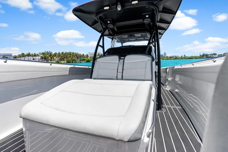 Slide: The Image of 2019 Nor-Tech 390 Sport Center Console boat with sleek seating and ocean backdrop. - 28
