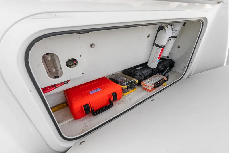 Slide: The Image of Storage compartment of 2019 Nor-Tech 390 Sport Center Console with safety equipment and tools. - 30