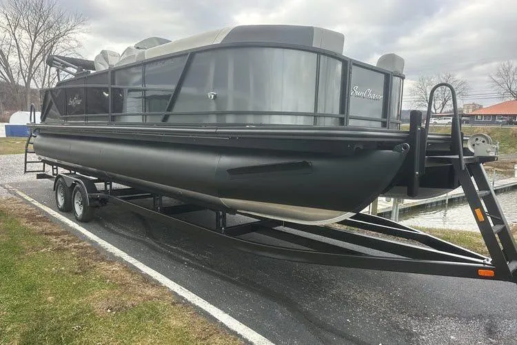 The Image of 2026 SunChaser Eclipse 25 SBX DH BAR pontoon boat on trailer, parked outdoors. - 0