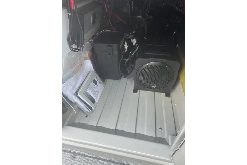 Slide: The Image of Interior view of 2026 SunChaser Eclipse 25 SBX DH BAR, showcasing audio equipment and storage area. - 16