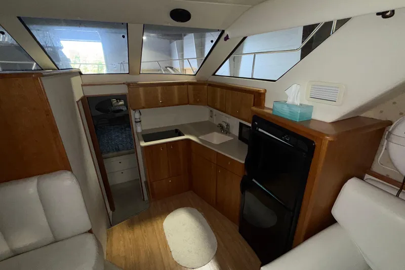 Slide: The Image of Interior of 2001 Silverton 351 Sedan yacht with kitchenette and seating area. - 14
