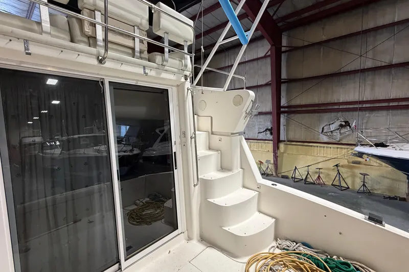 Slide: The Image of 2001 Silverton 351 Sedan yacht interior with stairs and sliding glass door in a boatyard. - 5