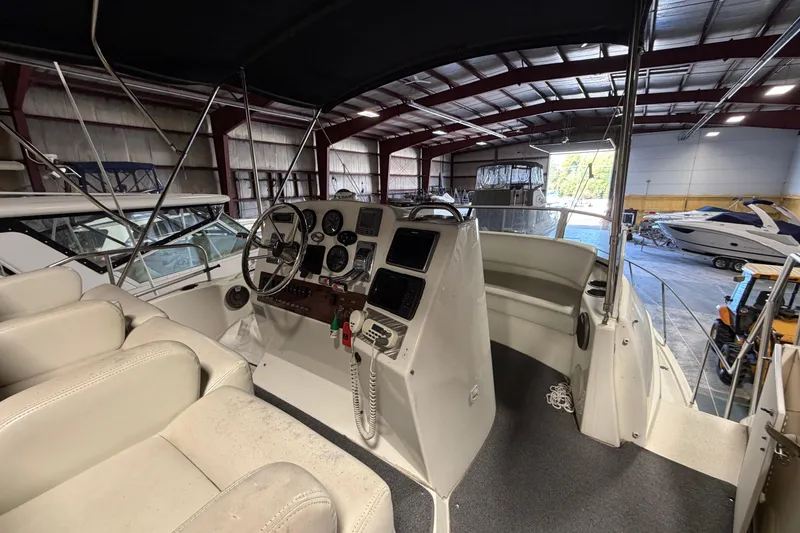 Slide: The Image of 2001 Silverton 351 Sedan boat interior with helm, steering wheel, and gauges in a storage facility. - 7