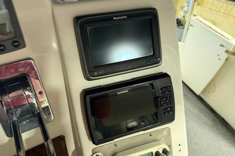 Slide: The Image of Control panel of a 2001 Silverton 351 Sedan with Raymarine and Garmin displays. - 8