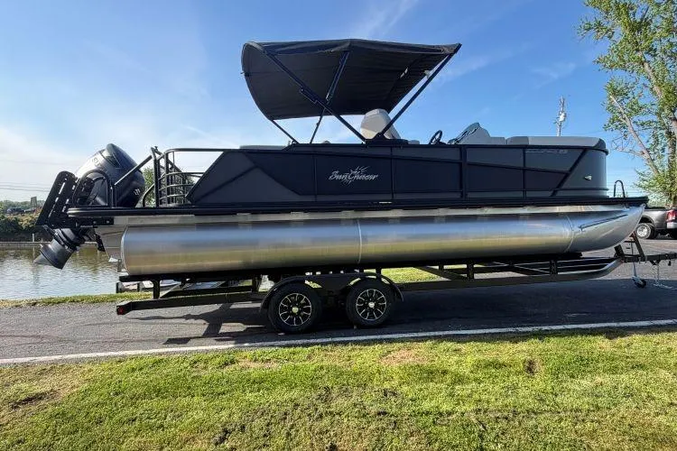 The Image of 2026 SunChaser Eclipse 23 SB DH pontoon boat on trailer, parked by a scenic riverside. - 0