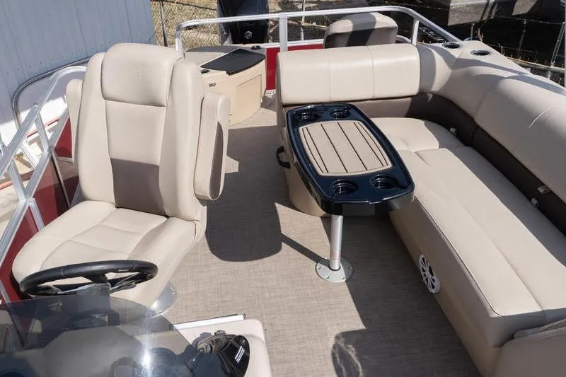 Slide: The Image of 2019 Sun Tracker Fishin' Barge 22 DLX interior with beige seating and table. - 12