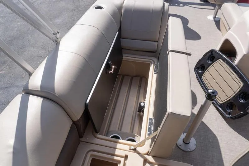 Slide: The Image of 2019 Sun Tracker Fishin' Barge 22 DLX interior storage compartment with beige seating. - 14