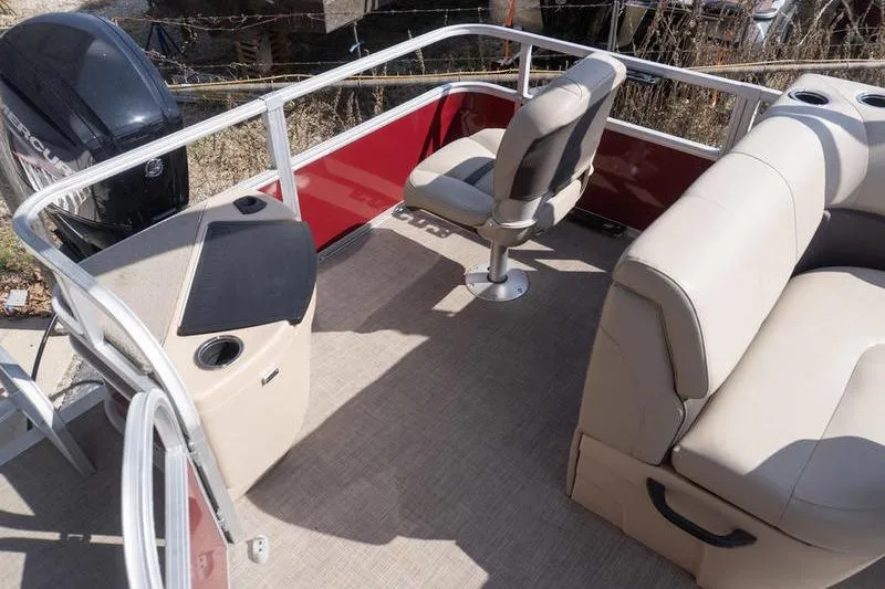 Slide: The Image of 2019 Sun Tracker Fishin' Barge 22 DLX interior with seating and motor view. - 19