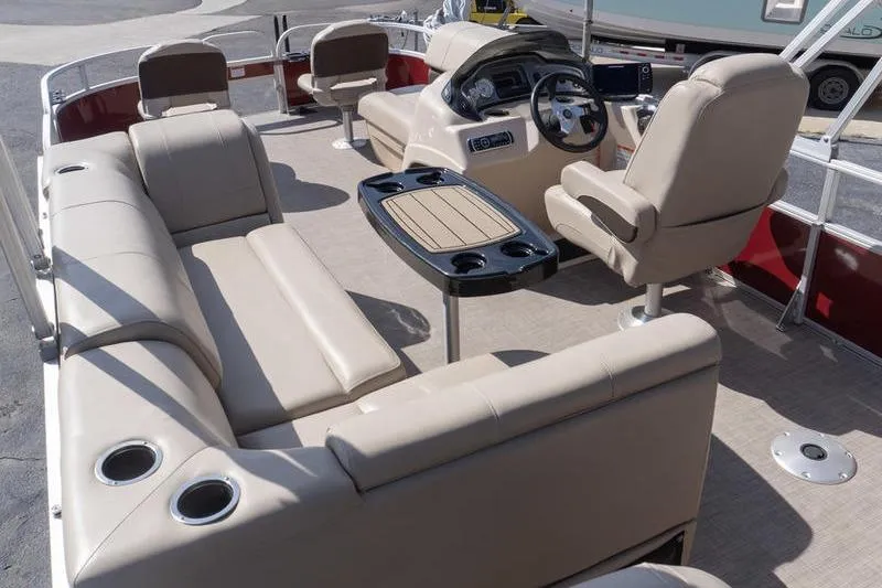 Slide: The Image of 2019 Sun Tracker Fishin' Barge 22 DLX interior with beige seating and steering console. - 7