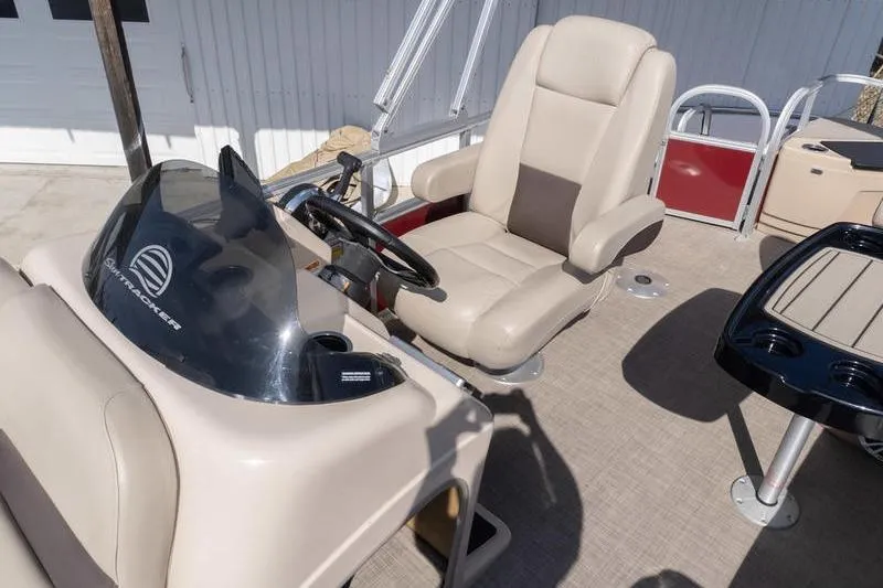 Slide: The Image of 2019 Sun Tracker Fishin' Barge 22 DLX interior with captain's chair and steering console. - 8