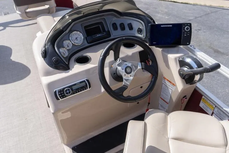 Slide: The Image of 2019 Sun Tracker Fishin' Barge 22 DLX helm with steering wheel and control panel. - 9