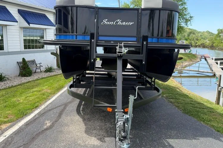 Slide: The Image of 2026 SunChaser Geneva Sport 23 LR DH pontoon boat on trailer by lakeside. - 4