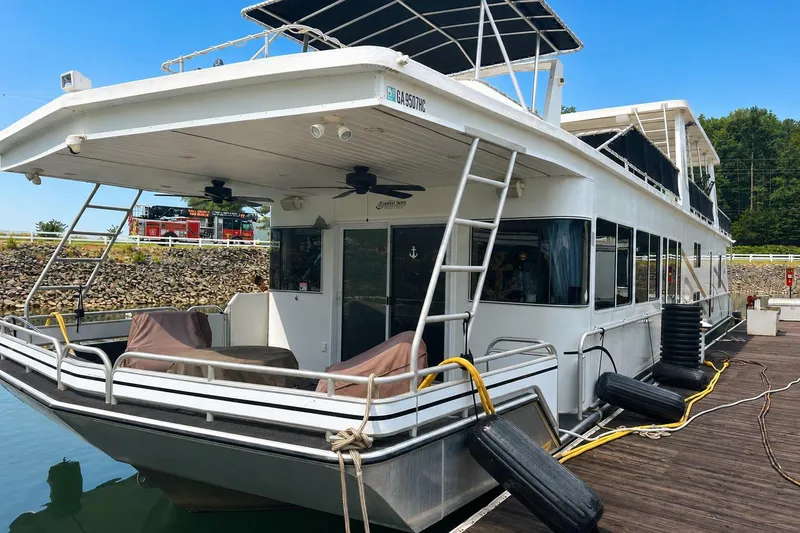 The Image of Houseboat docked at marina, Fantasy 18x75 model, 2007, with outdoor seating and ladder. - 0