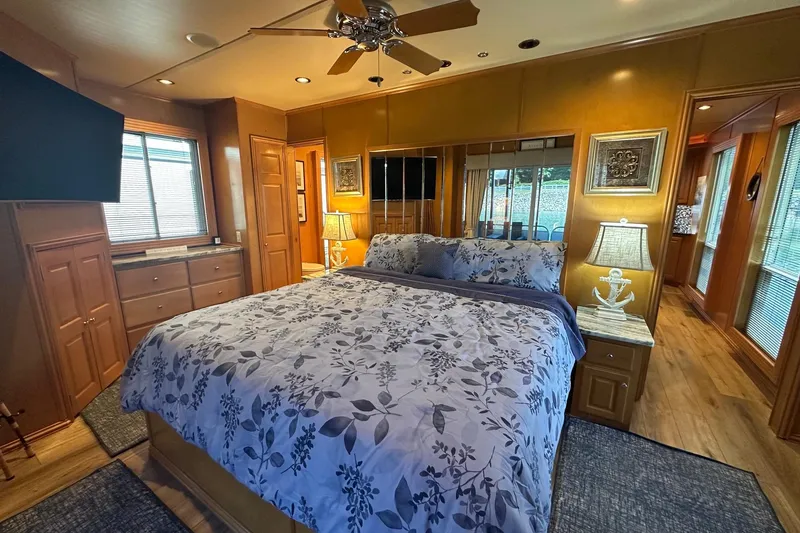 Slide: The Image of Cozy bedroom with floral bedding, wooden decor, and ceiling fan in a 2007 Fantasy 18x75 model. - 10