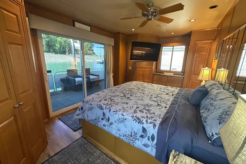 Slide: The Image of Cozy bedroom in 2007 Fantasy 18x75 houseboat with lake view and floral bedding. - 11