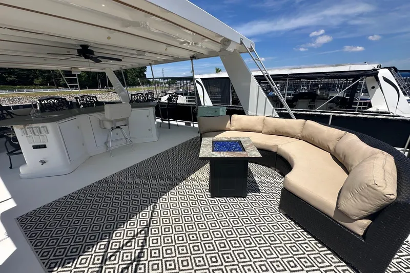 Slide: The Image of Luxurious 2007 Fantasy 18x75 yacht deck with seating, bar, and patterned rug under blue sky. - 15