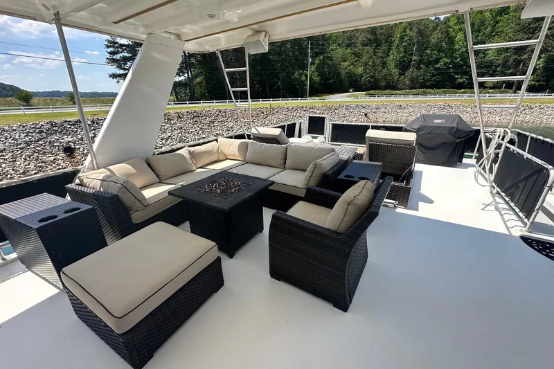 Slide: The Image of Luxurious outdoor seating on a 2007 Fantasy 18x75 houseboat, featuring wicker furniture and scenic views. - 17