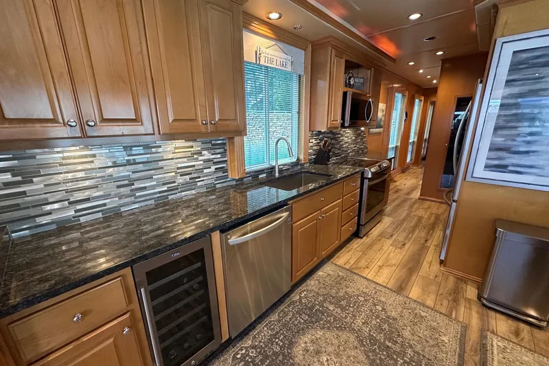 Slide: The Image of Modern kitchen with wooden cabinets, granite countertops, and stainless steel appliances in a 2007 Fantasy model. - 3