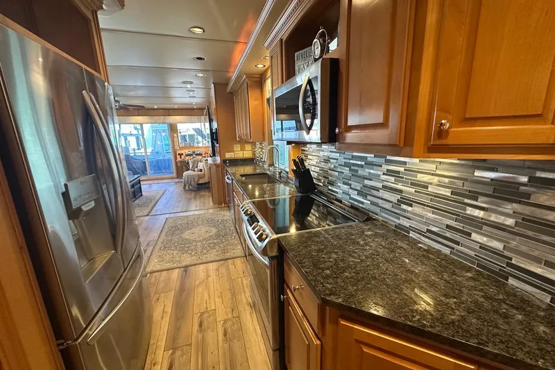Slide: The Image of Luxurious kitchen in a 2007 Fantasy 18x75 houseboat with modern appliances and wood cabinetry. - 4