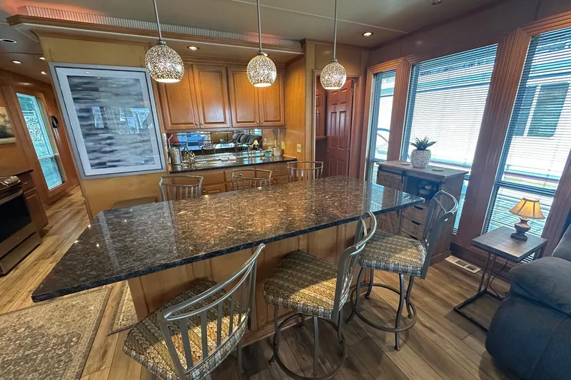 Slide: The Image of Luxurious kitchen interior with granite countertop, wooden cabinets, and modern lighting in a 2007 Fantasy 18x75 model. - 5