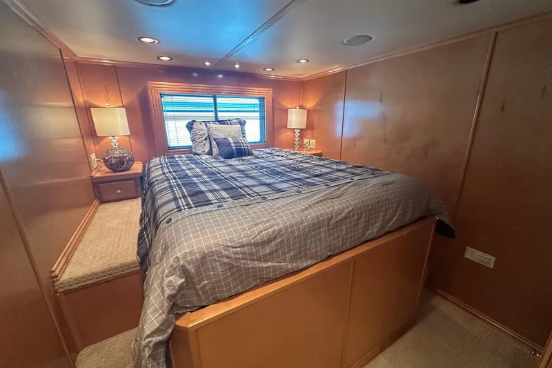 Slide: The Image of Cozy bedroom with plaid bedding in a 2007 Fantasy 18x75 houseboat, featuring warm wood paneling. - 6