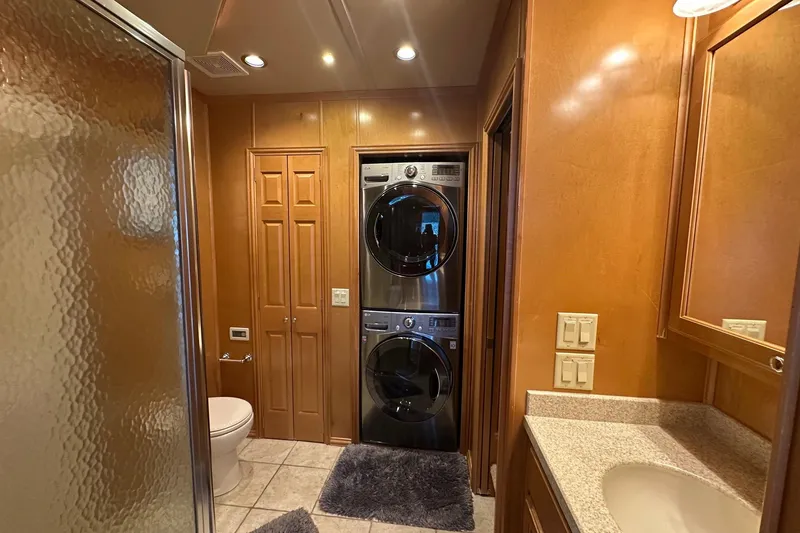Slide: The Image of Modern bathroom with stacked washer-dryer, glass shower, and wooden cabinetry, Fantasy 18x75, 2007. - 9