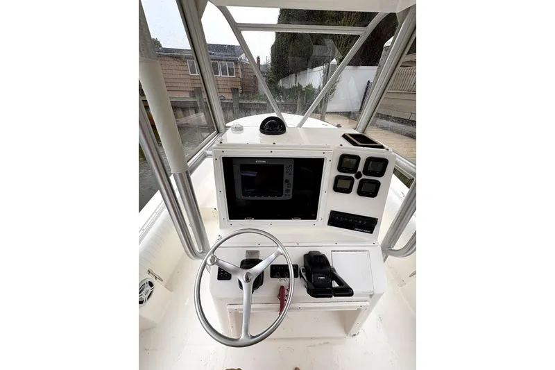 Slide: The Image of Helm of 2006 Regulator 24 Classic boat with steering wheel and navigation controls. - 1