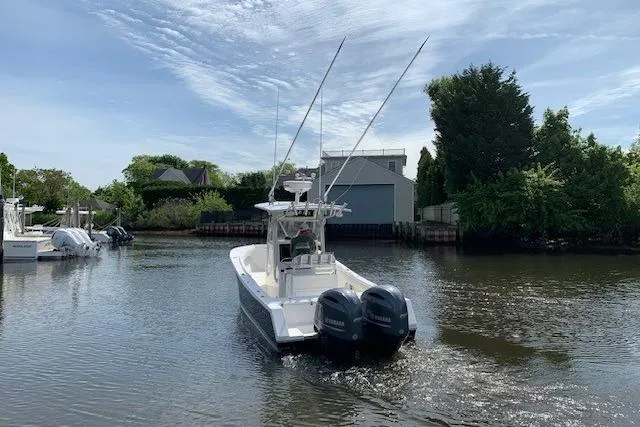 Slide: The Image of 2006 Regulator 24 Classic boat with dual engines on a calm waterway. - 12
