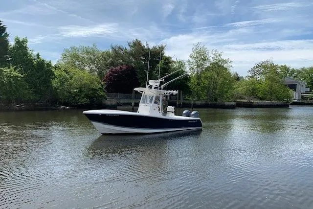 Slide: The Image of 2006 Regulator 24 Classic boat on a calm river, surrounded by lush greenery. - 19
