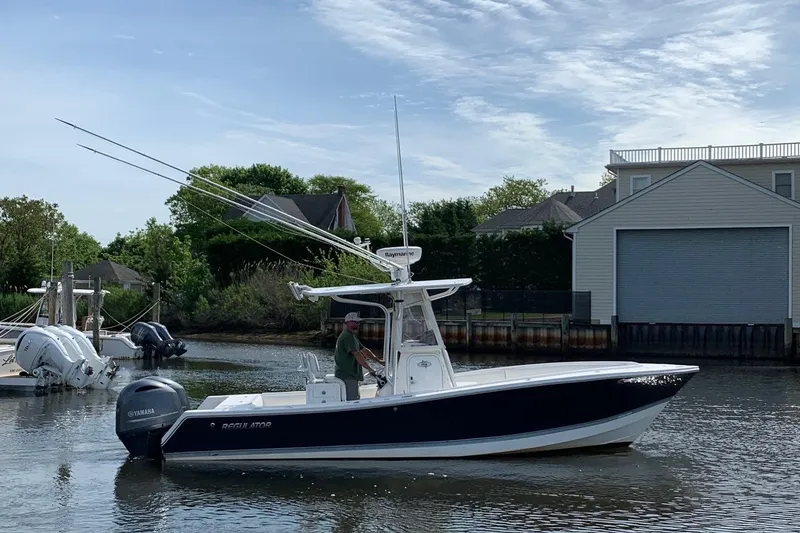 Slide: The Image of 2006 Regulator 24 Classic boat on water near dock, clear sky background. - 20