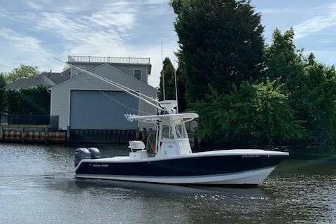 Slide: The Image of 2006 Regulator 24 Classic boat on a calm river near a boathouse. - 24