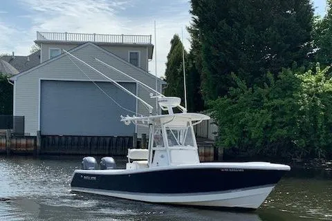Slide: The Image of 2006 Regulator 24 Classic boat on a calm waterway near a boathouse and trees. - 26