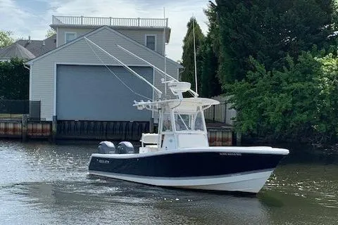 Slide: The Image of 2006 Regulator 24 Classic boat on water near a boathouse and trees. - 27