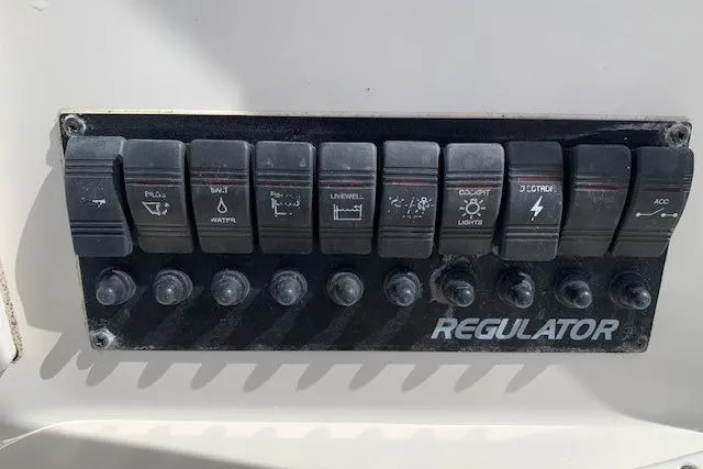 Slide: The Image of Control panel of a 2006 Regulator 24 Classic boat with labeled switches. - 38