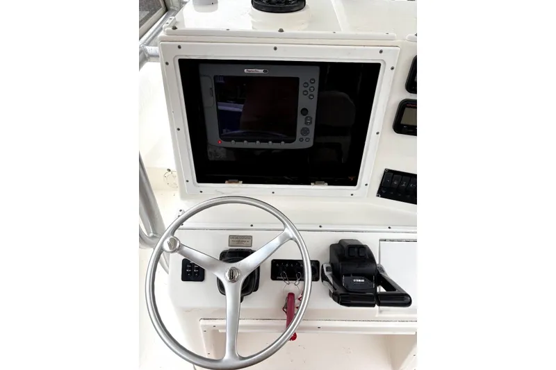 Slide: The Image of 2006 Regulator 24 Classic boat dashboard with steering wheel and navigation equipment. - 4