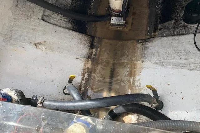 Slide: The Image of Bilge area of a 2006 Regulator 24 Classic boat with hoses and water accumulation. - 45