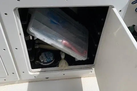 Slide: The Image of Open storage compartment on a 2006 Regulator 24 Classic boat with fishing gear. - 48