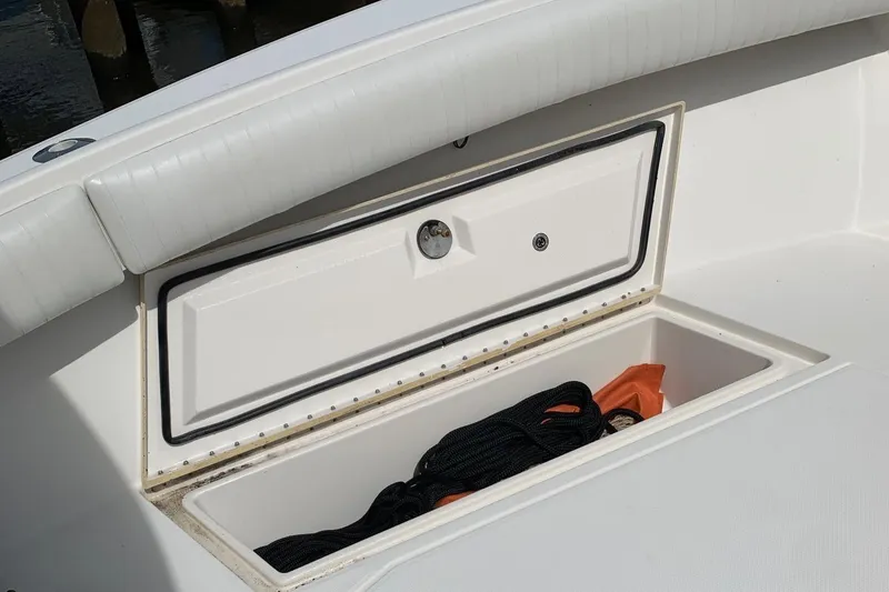 Slide: The Image of Open storage compartment on a 2006 Regulator 24 Classic boat, containing rope and equipment. - 55