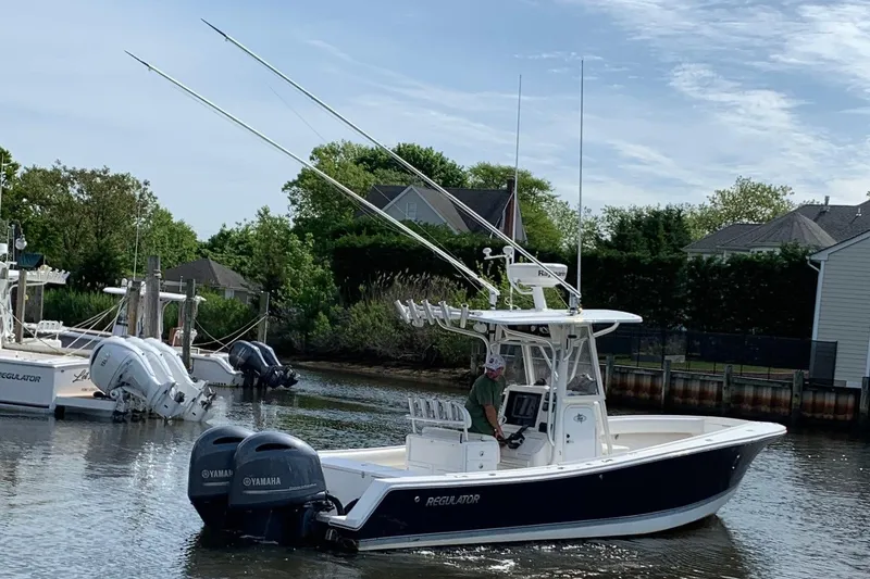 Slide: The Image of 2006 Regulator 24 Classic boat with dual Yamaha engines docked in a serene marina. - 73